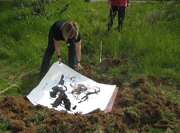 Christina Oiticica enterrando uno de sus lienzos