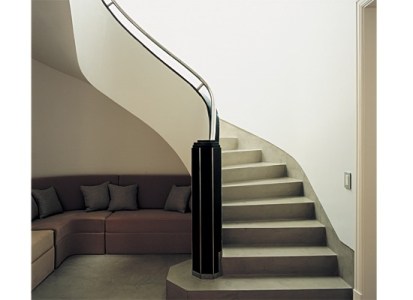 Escalera con torre facetada de mármol negro, baranda cromada. Para el rincón que deja libre, se encargó un sillón a medida (Monica Maestri)